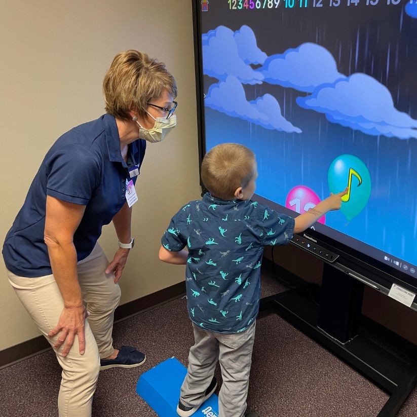 Child playing with large touchscreen video screen