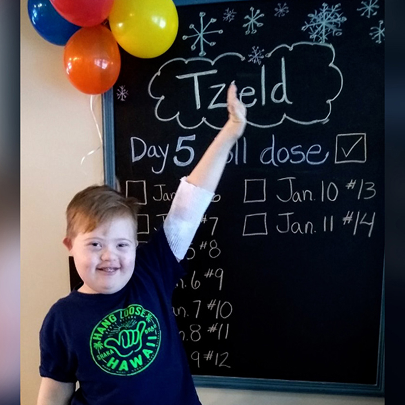 Image of happy young boy in front of chalkboard