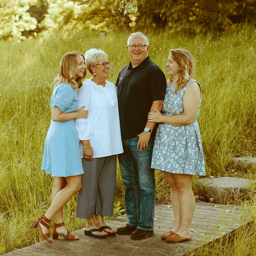 A family of four smiling outside